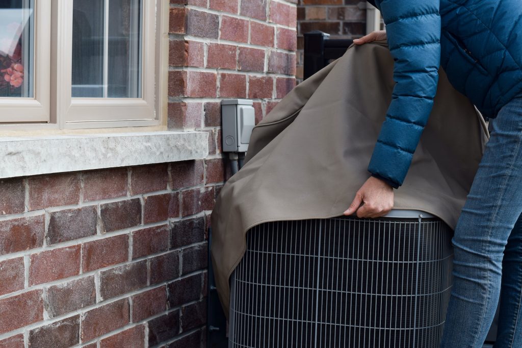 Putting cover on air conditioner unit